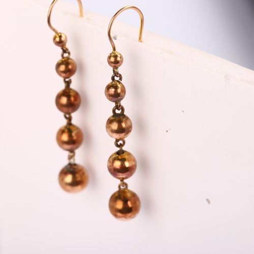 1209 - A pair of graduated ball drop earrings, unmarked yellow metal settings, with shepherd hook fittings,... 