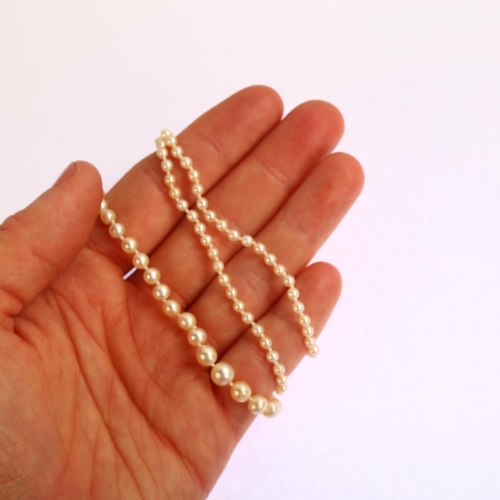 1212 - An Antique graduated single-strand pearl necklace, with unmarked gold rose-cut diamond clasp, pearls... 