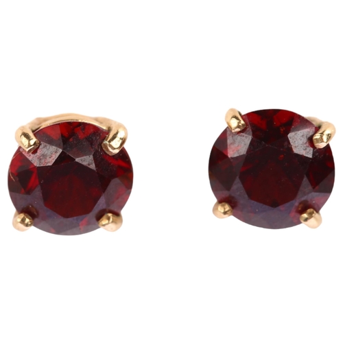 1224 - A pair of solitaire garnet earrings, unmarked yellow metal settings with stud fittings, garnet diame... 