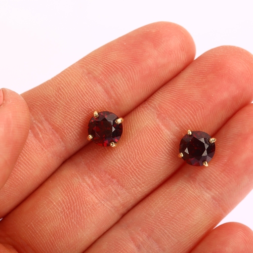 1224 - A pair of solitaire garnet earrings, unmarked yellow metal settings with stud fittings, garnet diame... 