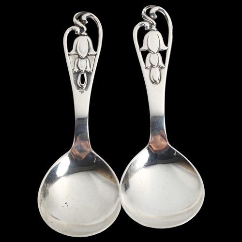 1470 - A pair of Art Deco Danish stylised silver preserve spoons, with pierced floral handles, length 11cm