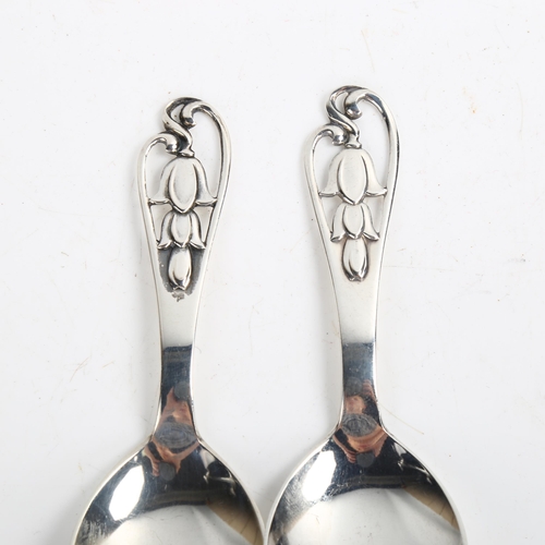 1470 - A pair of Art Deco Danish stylised silver preserve spoons, with pierced floral handles, length 11cm