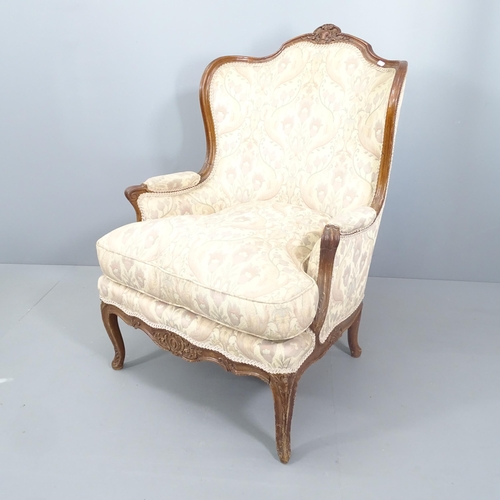 2117 - A continental mahogany and upholstered lounge chair, with carved decoration and raised on five legs.... 