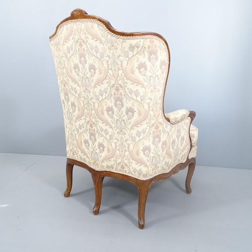 2117 - A continental mahogany and upholstered lounge chair, with carved decoration and raised on five legs.... 