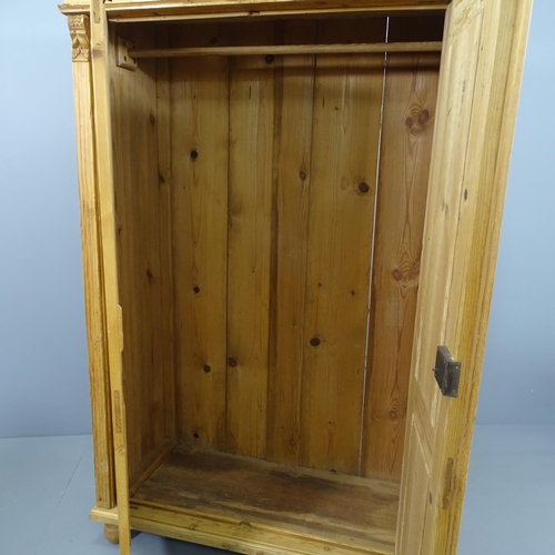 2129 - A pine two-door wardrobe, with rail fitted interior and raised on bun feet. 113x177x54cm