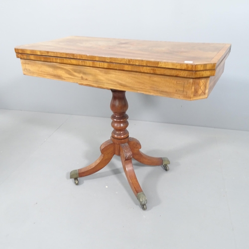 2179 - A 19th century cross banded mahogany fold over card table, turned centre column and sabre leg base. ... 