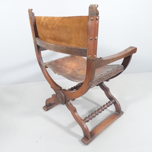 2195 - An antique oak Savonarola chair with carved decoration and studded leather seat.