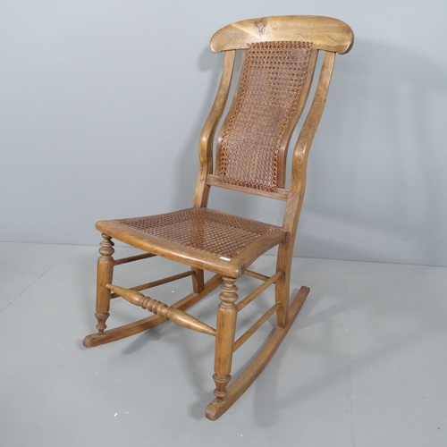 2213 - An elm and oak cane back rocking chair