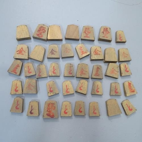 2216 - A Japanese Shogi set comprising a wooden game board and counters. 35x21x31cm.