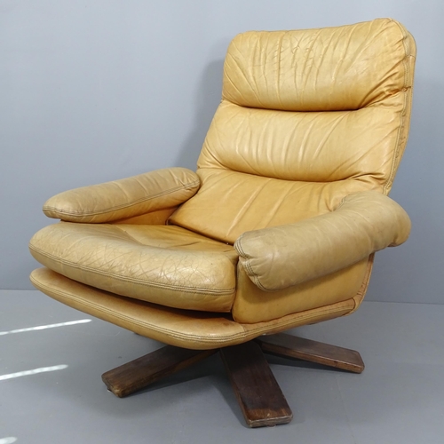 2012 - A mid-century Danish design teak and leather upholstered swivel lounge chair.