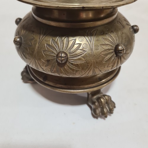 136 - A 19th century brass candle stand on brass lion paw feet, height 32cm