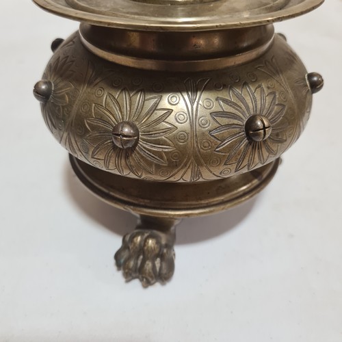 136 - A 19th century brass candle stand on brass lion paw feet, height 32cm