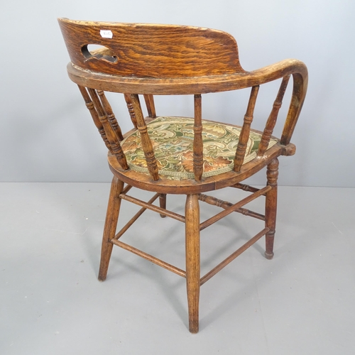 2250 - An antique oak captain's chair with floral upholstered seat.