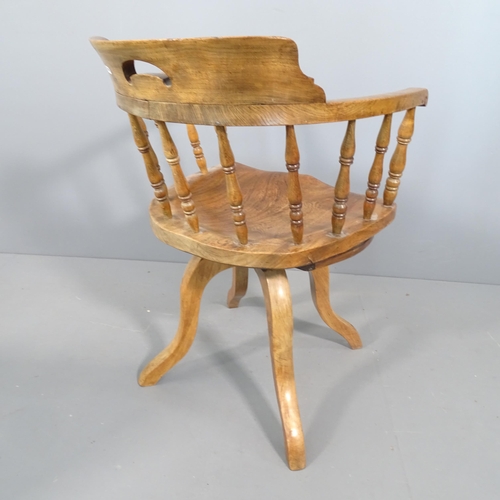 2257 - An antique elm seated captain's chair.