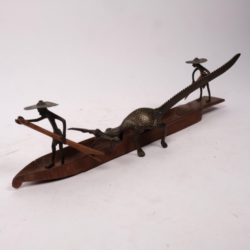 296 - Circa 1920s, a Nigerian bronze fishing group depicting fishermen paddling while their comrade is bei... 