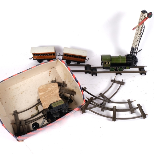 102 - A quantity of Vintage German tinplate trains and associated accessories, including a locomotive, car... 