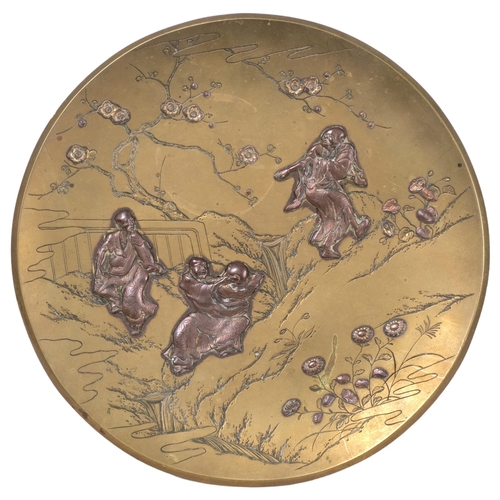 191 - A Japanese bronze and mixed metal charger, depicting figures in a mountain landscape, signed to the ... 