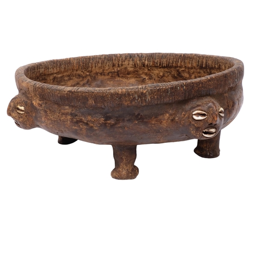 206 - A Polynesian footed bowl, possibly cowhide, with 4 faces each with cowrie shell eyes and mouth, diam... 