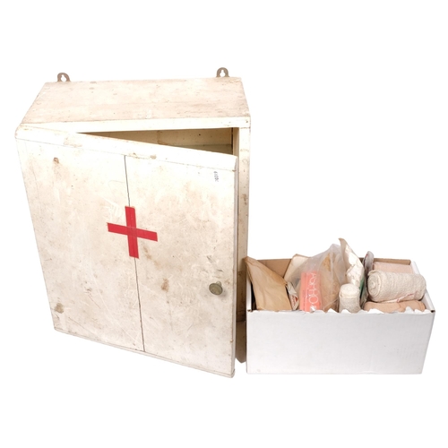 213 - A painted First Aid cabinet, with glass shelves and some original contents including bandages, H47cm