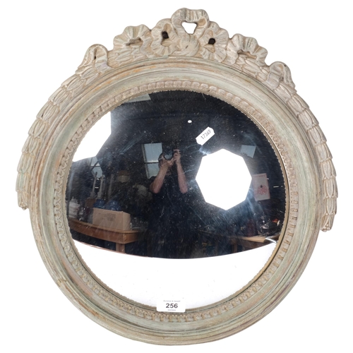 256 - A 1930s limed oak circular convex wall mirror, with ribbon pediment, diameter 41cm