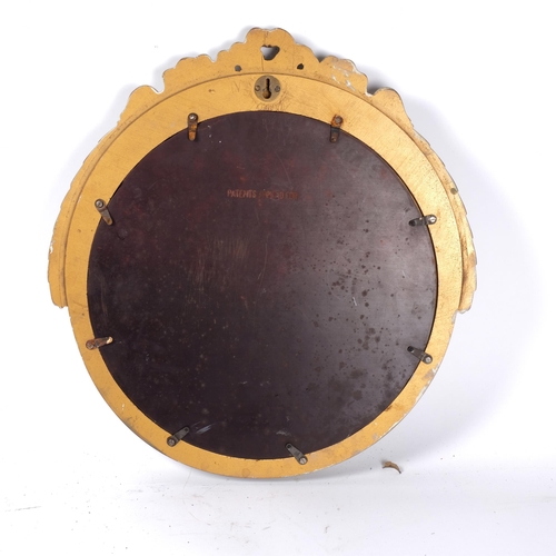 256 - A 1930s limed oak circular convex wall mirror, with ribbon pediment, diameter 41cm