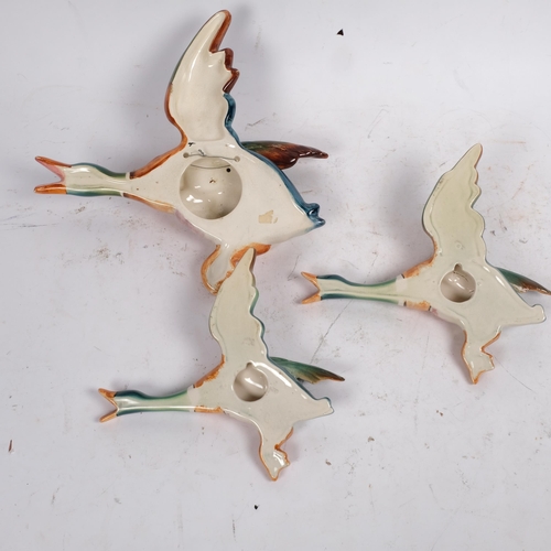 495 - A graduated set of 3 painted pottery flying duck wall ornaments, largest length 29cm