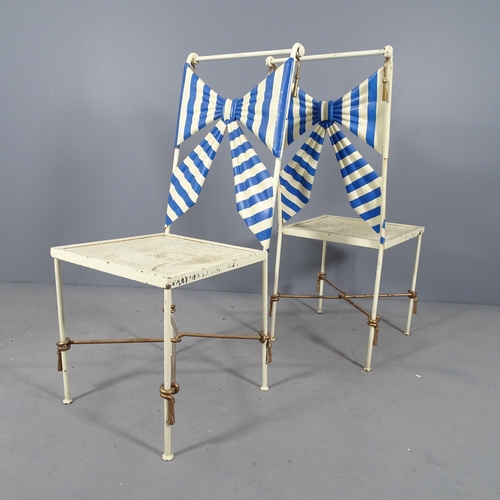 2701 - A set of four painted metal chairs, with bow back decoration and cushions.