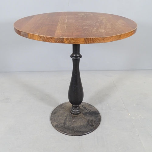 2704 - An oak circular-top pub table on painted cast iron base. 72x75cm.