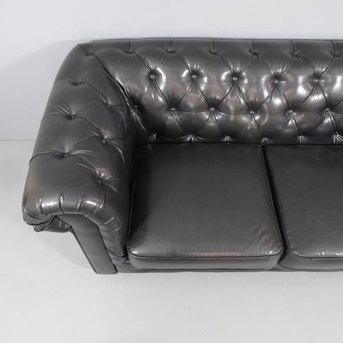 2050 - A black button back faux-leather upholstered two seater Chesterfield sofa. Overall 188x80x90cm, seat... 