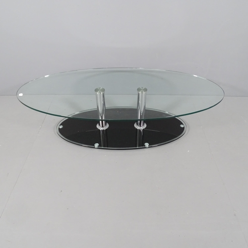 2041 - A contemporary oval glass top coffee table, on chrome supports with platform base. 135x34x65cm.