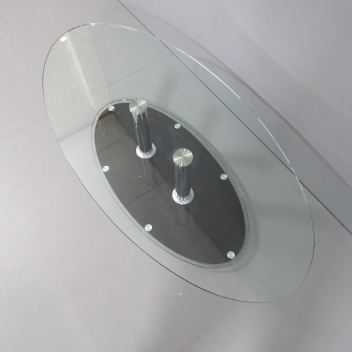 2041 - A contemporary oval glass top coffee table, on chrome supports with platform base. 135x34x65cm.