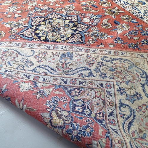 2302 - A red and cream-ground Isbahan carpet. 250x196cm.