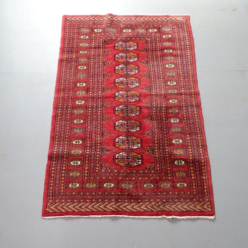 2306 - A red ground Afghan rug. 147x94cm.