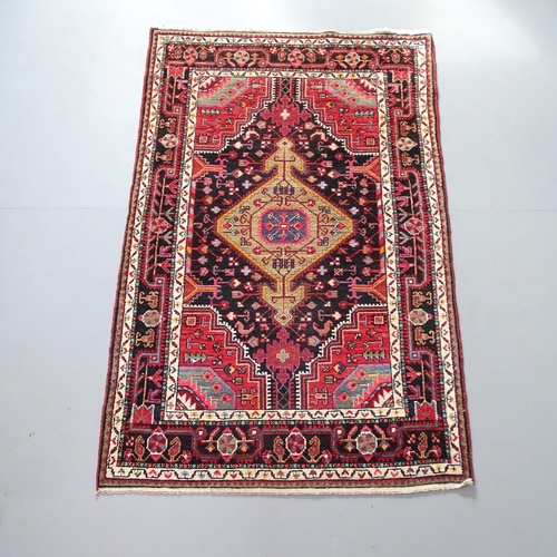 2310 - A red-ground Persian Hamadan rug. 180x114cm.