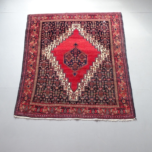 2315 - A red-ground Sarouk rug. 157x128cm.