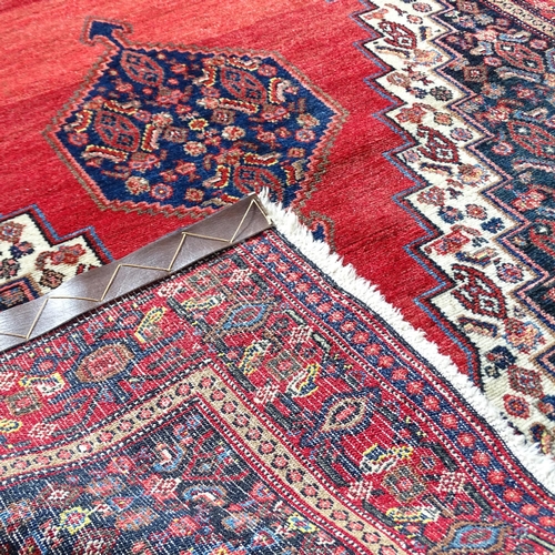 2315 - A red-ground Sarouk rug. 157x128cm.