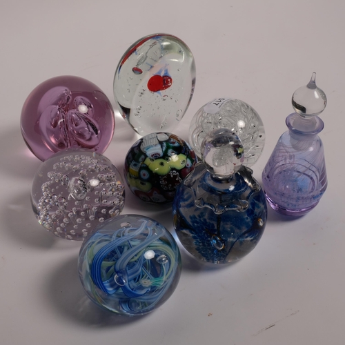 517 - A group of 7 glass paperweights, including Murano and Langham, and a scent flask