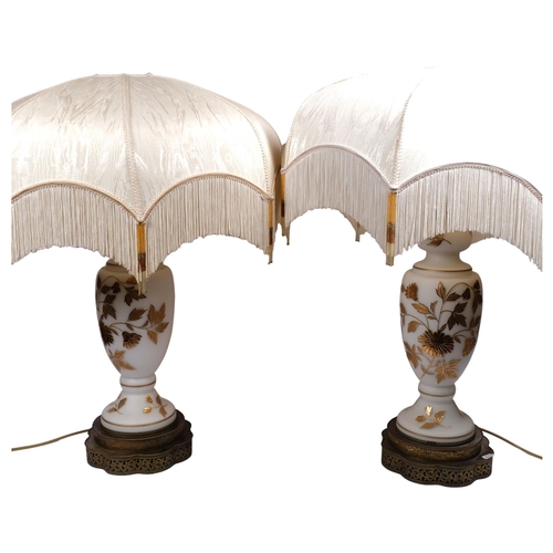 527 - A pair of impressive glass table lamps with applied gilded floral designs, on pierced brass shaped b... 