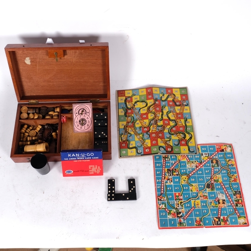 596 - A mahogany boxed games compendium, including dominos, draughts, and chess set etc