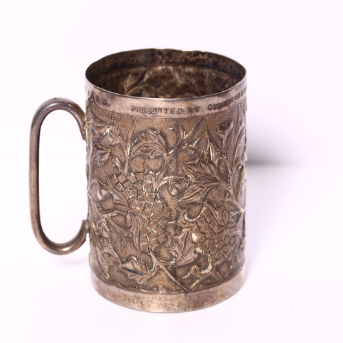 1010 - A Chinese white metal mug, with embossed and repousse floral decoration, with inscription to the top... 