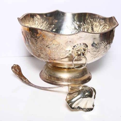 910 - A large silver plate on copper punch bowl and ladle, with repousse decoration and lion mask ring han... 