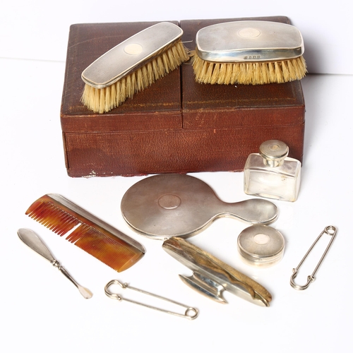 961 - A George V engine turned silver-backed travelling leather vanity case, comprising a small hand mirro... 