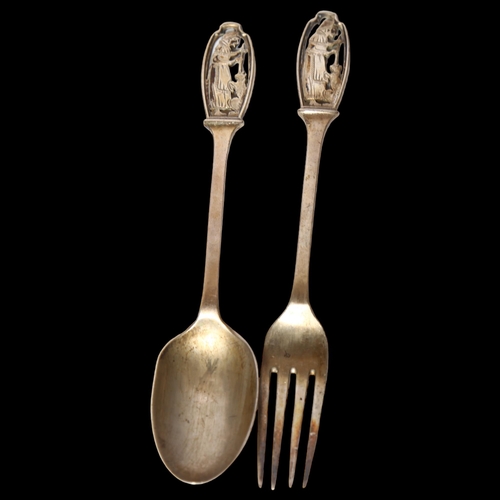 974 - A cased George V silver spoon and fork, with pierced figural decorated handles, hallmarks for London... 