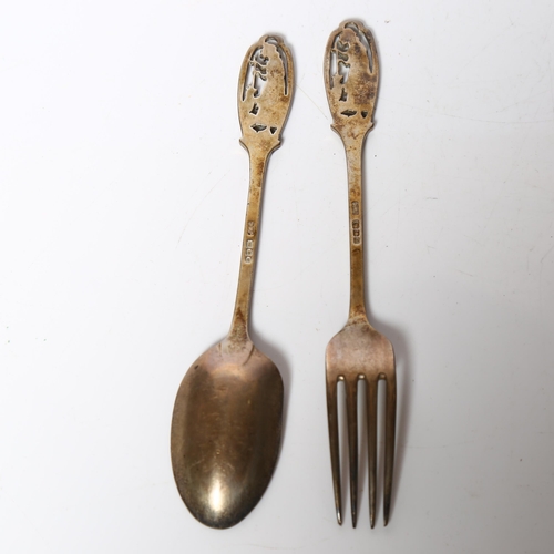 974 - A cased George V silver spoon and fork, with pierced figural decorated handles, hallmarks for London... 