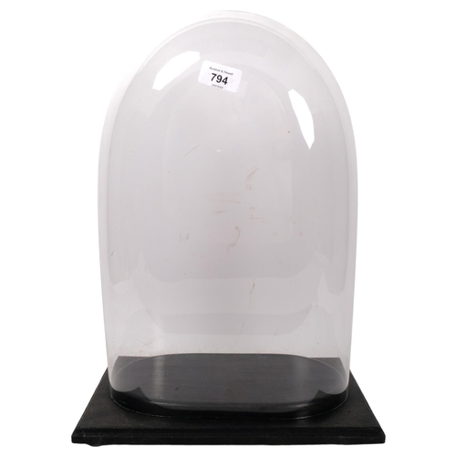 794 - A modern glass dome, on fitted wooden display stand, height including display stand 43cm, length 31c... 