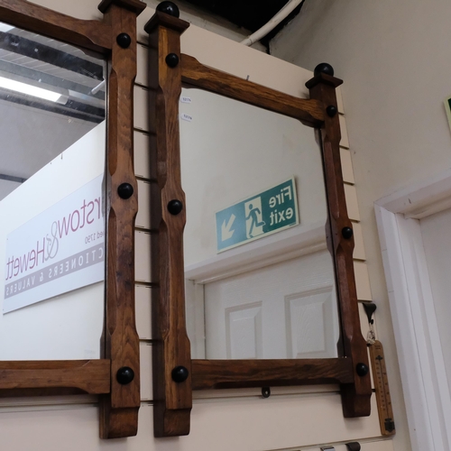 828 - A pair of oak Arts and Crafts wall-hanging mirrors, with turned mounts, 81cm x 50cm