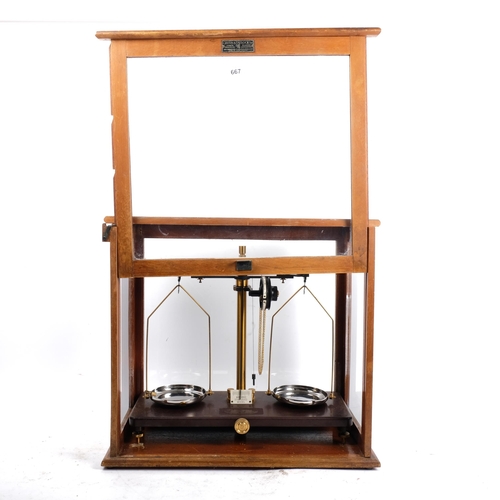 667 - A Griffin & Tatlock cased laboratory scale, with oak frame and sliding door, H40.5cm overall