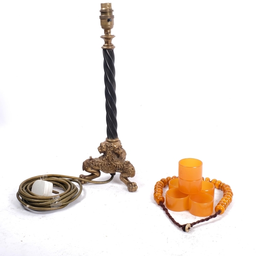 673 - A set of 6 amber Bakelite napkin rings, beads, and an Antique style table lamp on tripod brass lion ... 