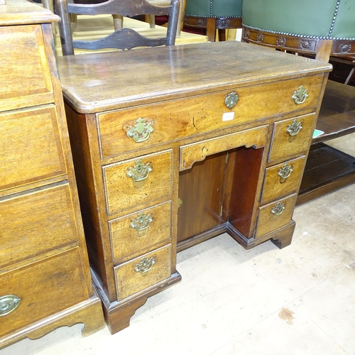 2064 - A George II oak kneehole writing desk, circa 1750, with 8 drawers and cupboard. Overall 84x77x51, kn... 