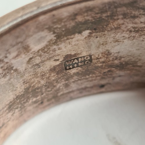 1013 - A Chinese embossed silver hinged bangle, panels decorated with hunting figures, with maker's mark fo... 